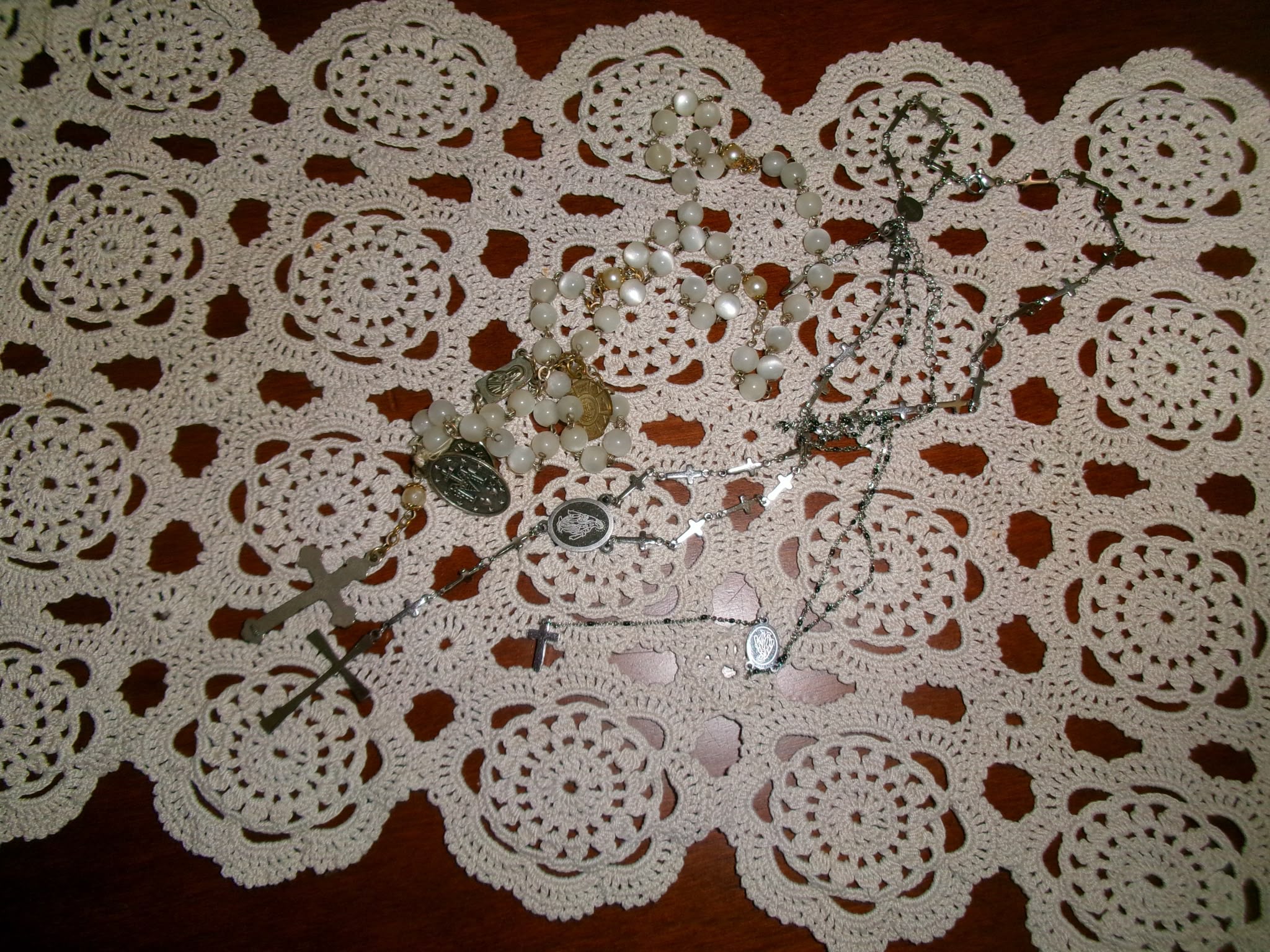 Rosari di perle e croci su centrino all'uncinetto